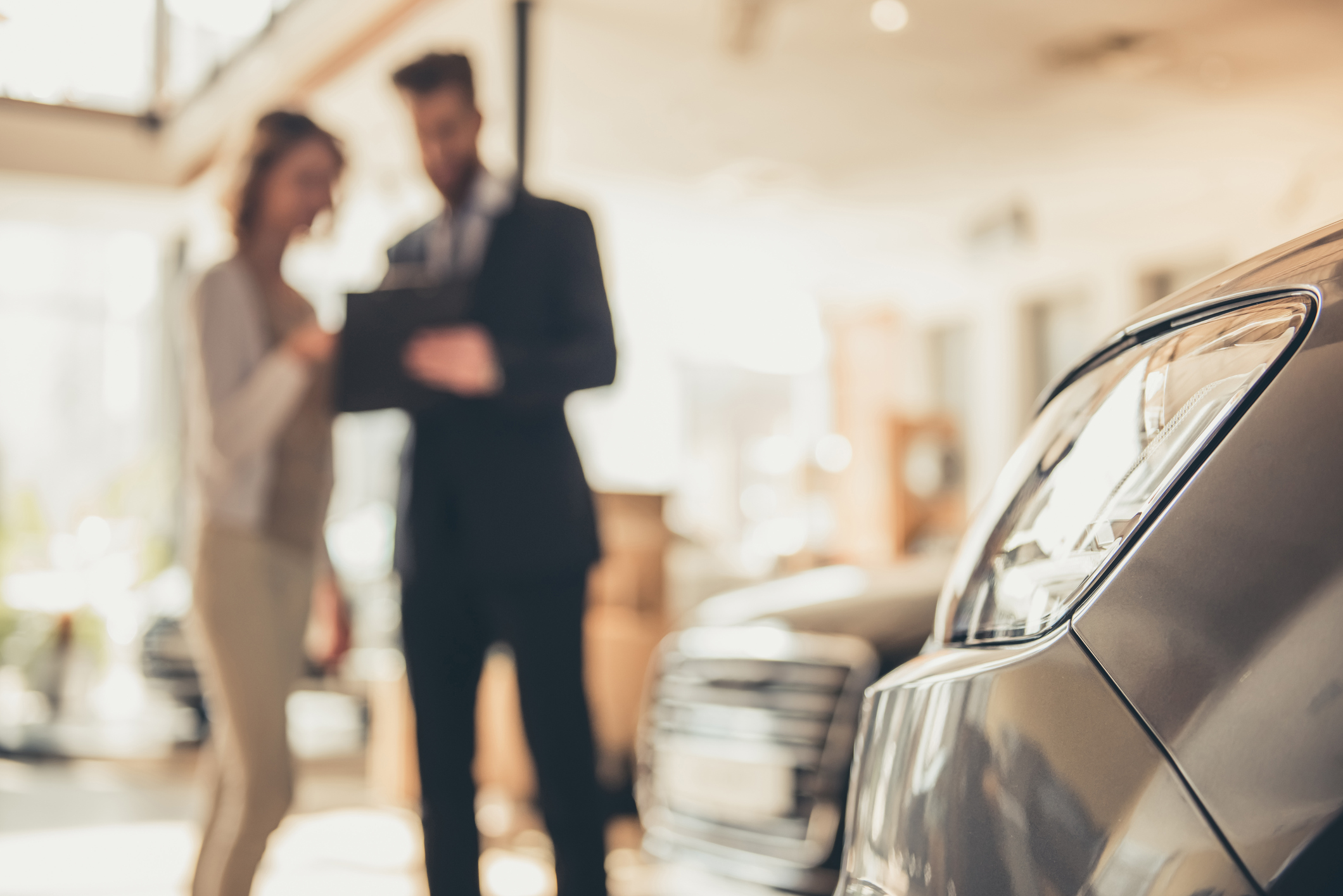 Kfz-Zulassung: So melden Sie Ihr neues Auto oder Motorrad an Mann und Frau führen Verkaufsgespräch im Autohaus.