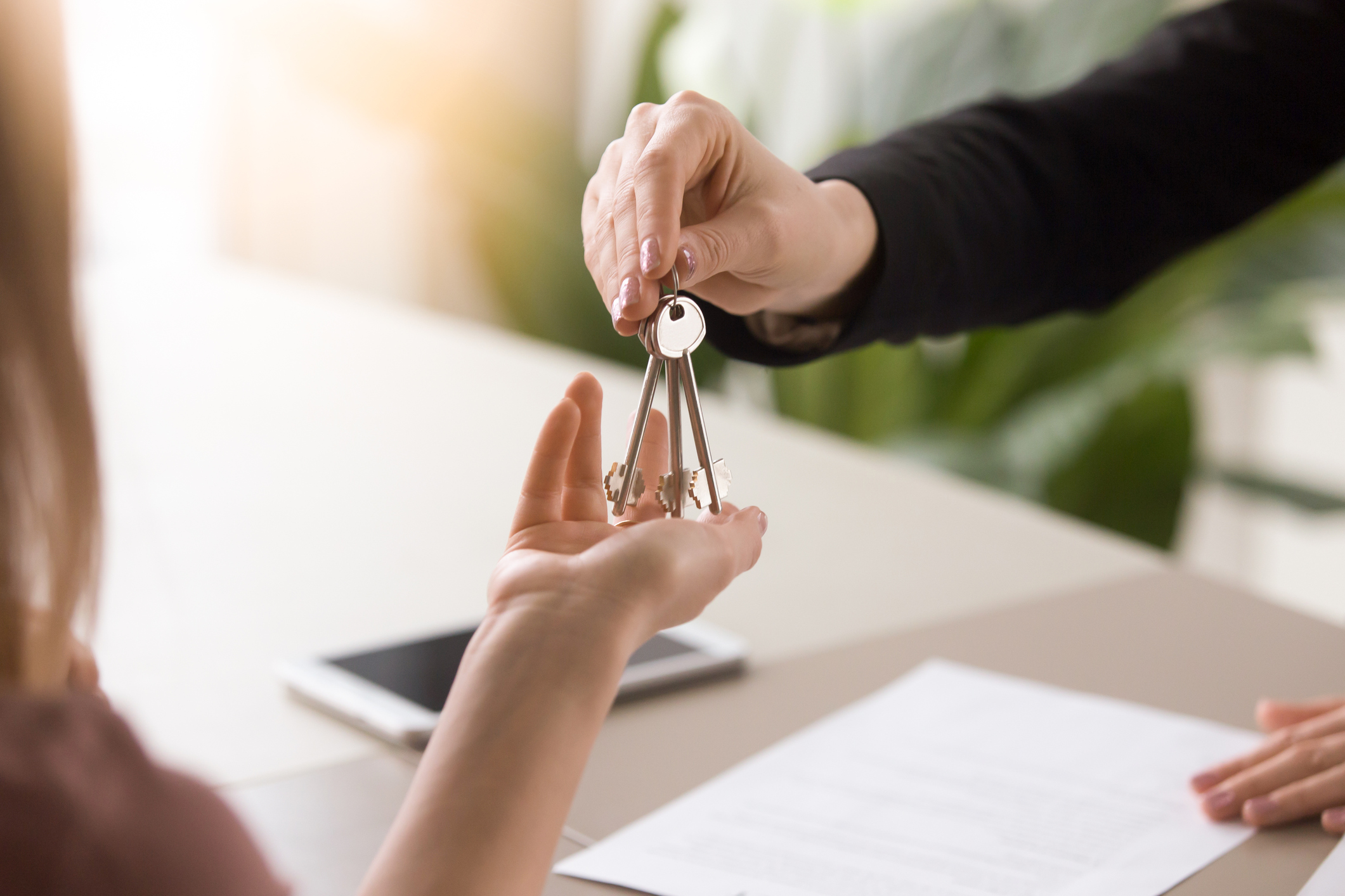 Wohnungsübergabe ohne Vermieter: Was Sie darüber wissen sollten Schlüssel wird von einer Hand in die andere gereicht