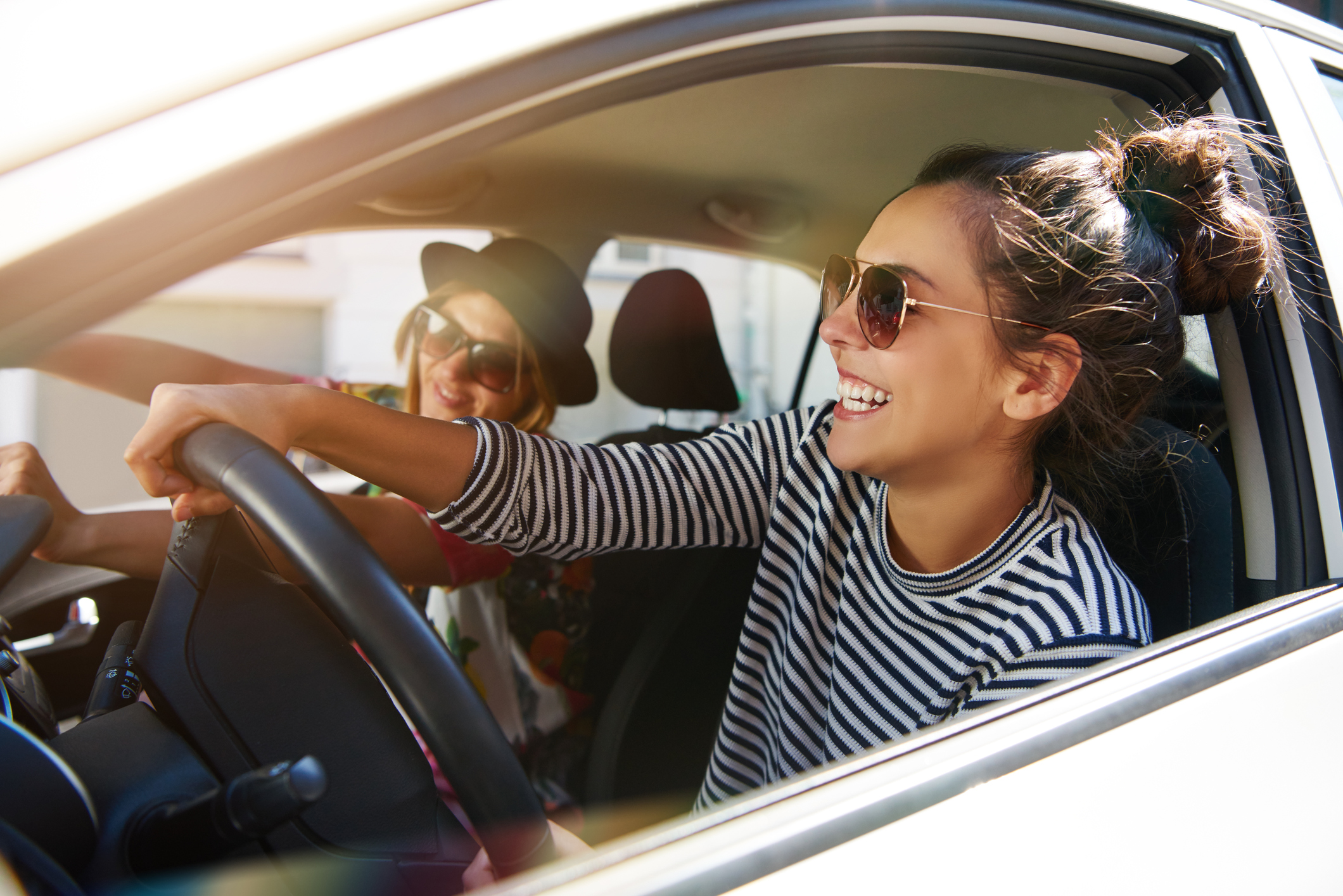 Kfz-Zulassung: So melden Sie Ihr neues Auto oder Motorrad an Zwei gut gelaunte Frauen fahren im Auto.