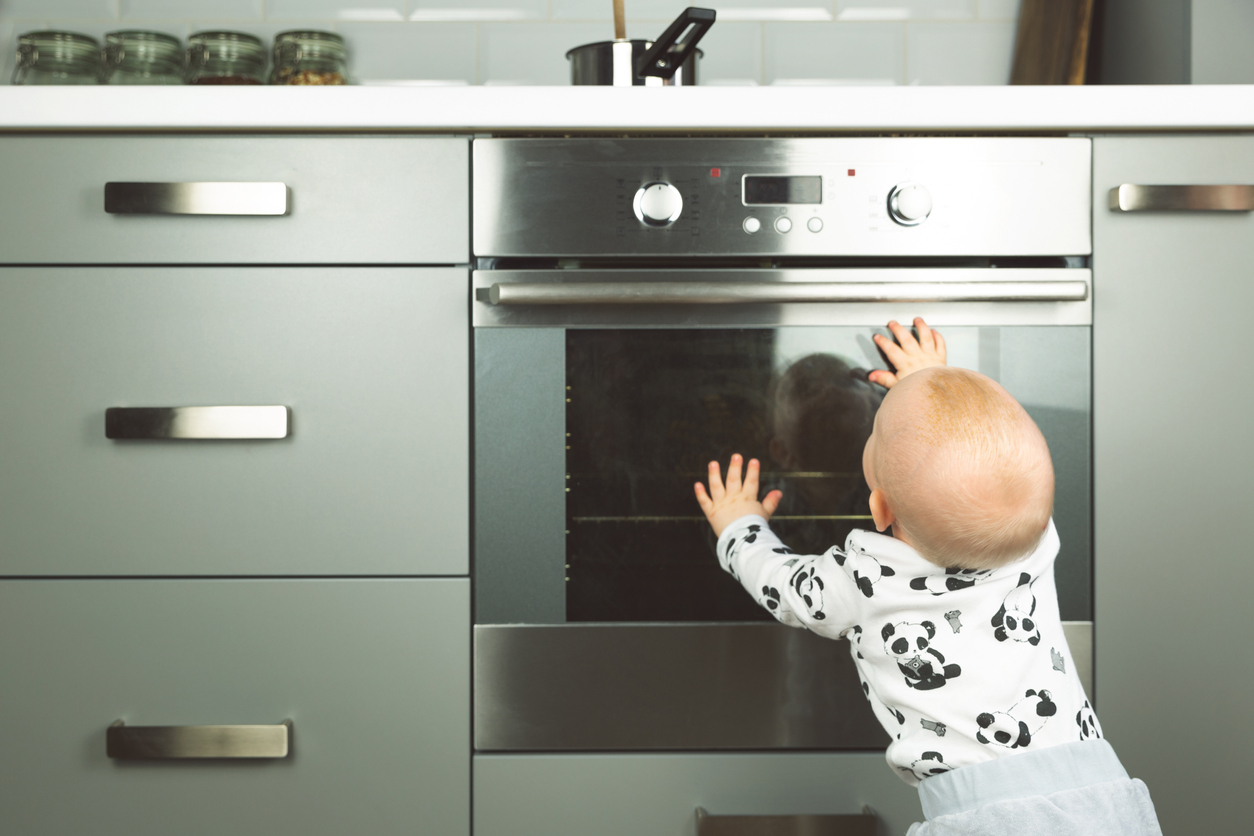 Wohnung kindersicher machen: Tipps und Tricks für Schränke, Steckdosen und Co. Baby am Herd