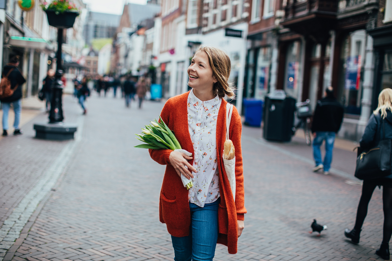 Auswandern in die Niederlande: Heimisch werden in Holland Frau mit Tulpen, die in die Niederlande ausgewandert ist