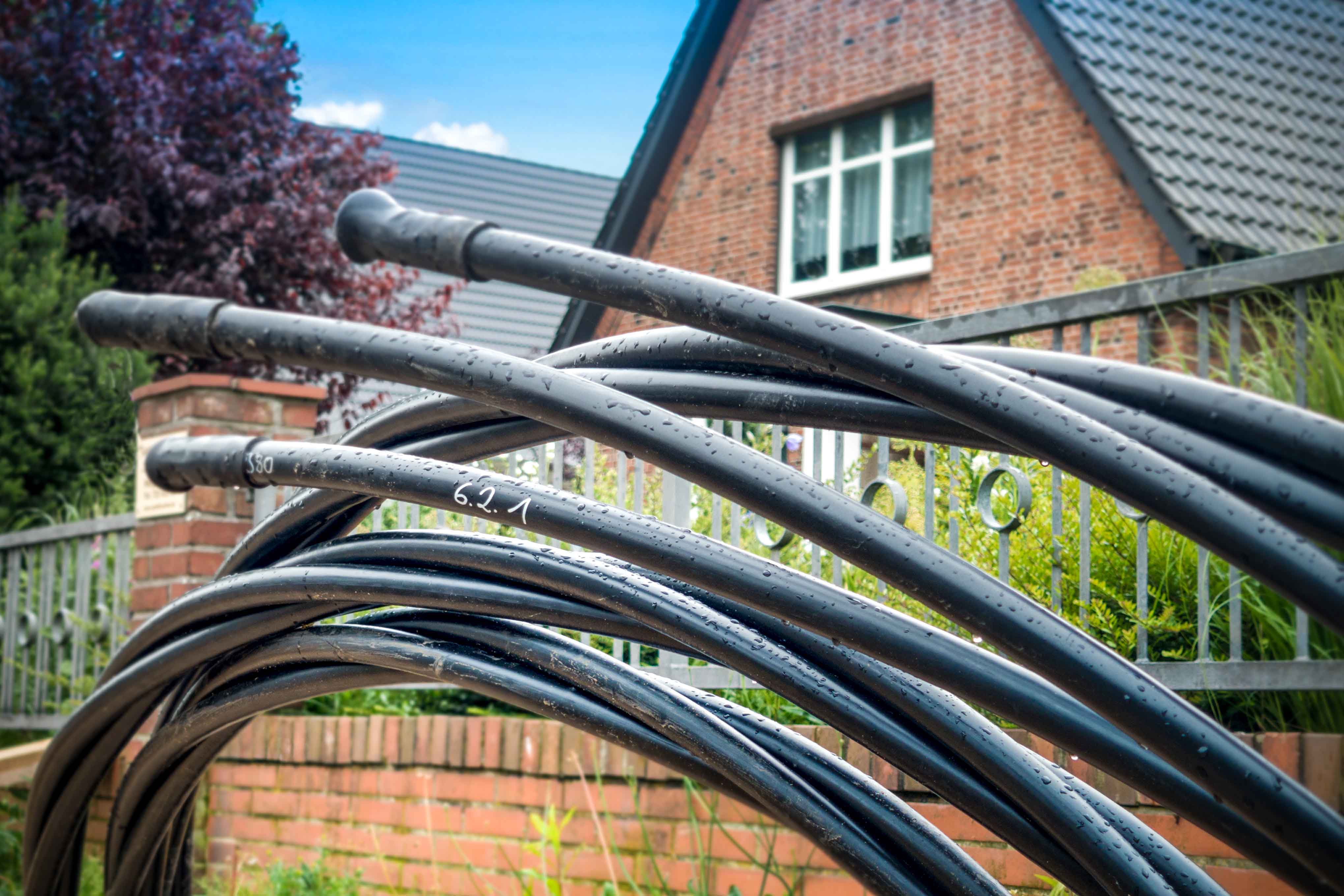 Kabelanschluss anmelden: Verfügbarkeit, Anbieter, Kosten Glasfaserkabel vor einem Backsteinhaus
