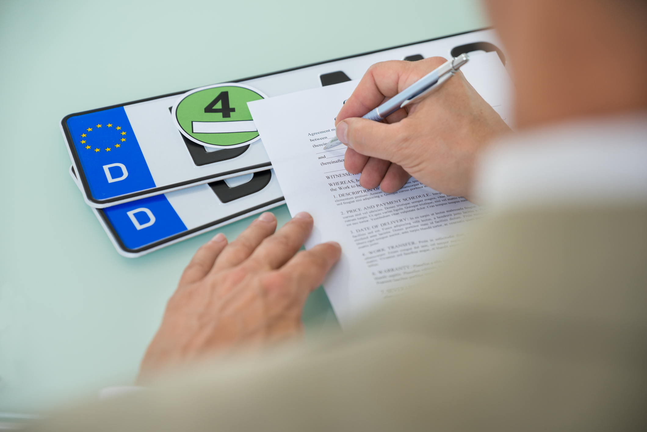 Mann füllt Formular zur Kfz Ummeldung aus