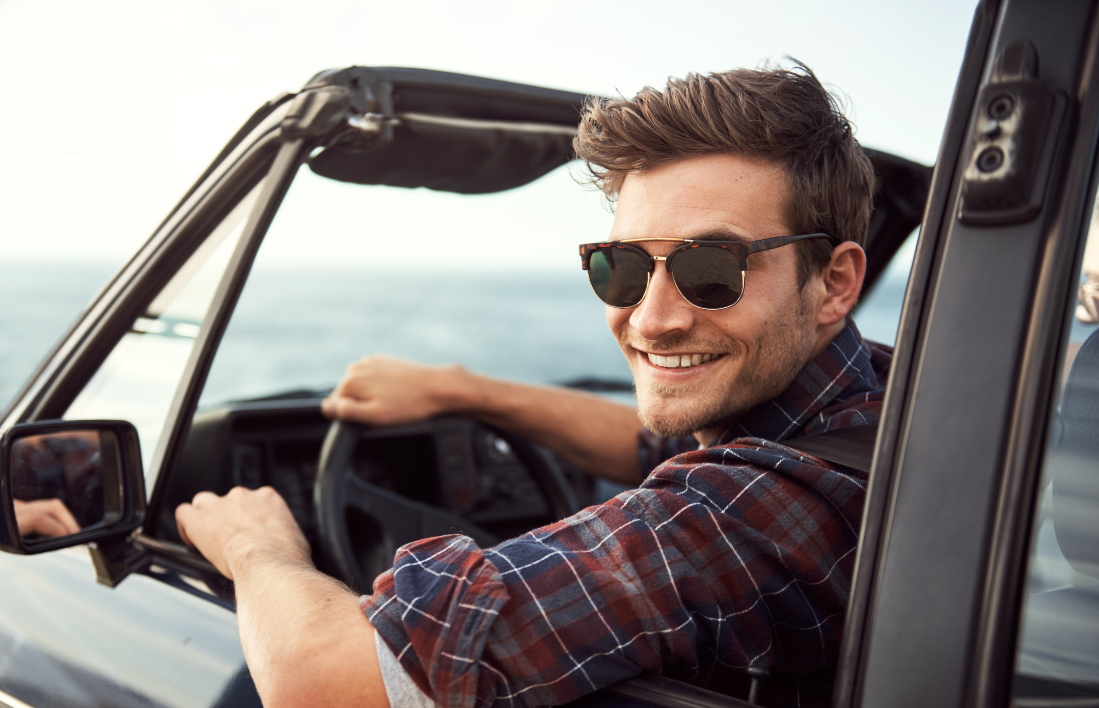 Junger Mann am Steuer eines Cabrio