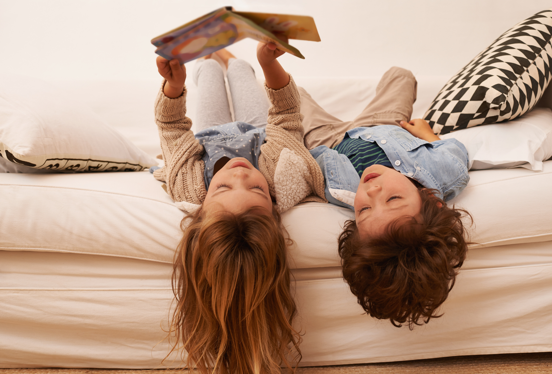 8 hilfreiche Kinderbücher zum Thema Umzug Zwei Kinder liegen auf einem Bett und lesen ein Buch