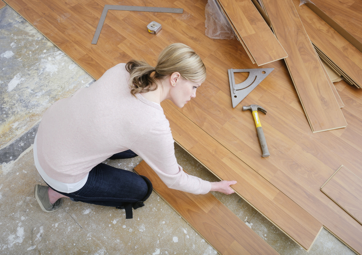 Laminat verlegen: Diese 6 Fehler sollten Sie vermeiden Frau verlegt Laminat