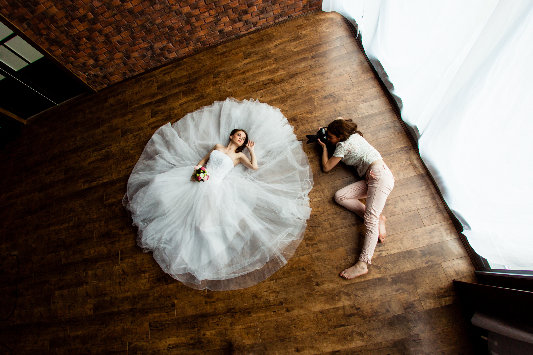 4 Dinge, die Sie in der leeren Wohnung tun können Fotografin und und Model beim Brautshooting auf dem Fußboden in einer leeren Wohnung