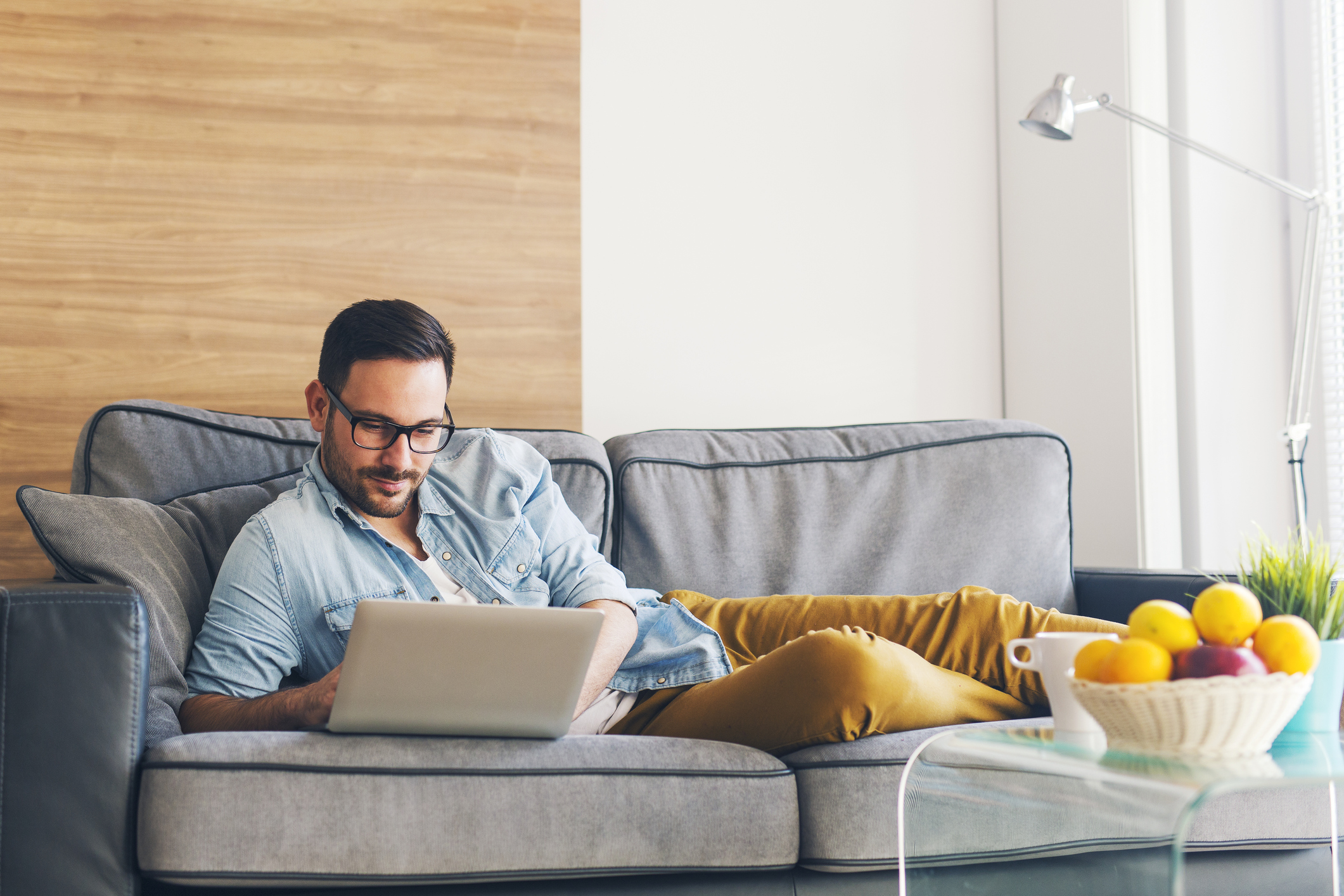 Mann mit Laptop auf Couch Mann mit Laptop auf Couch