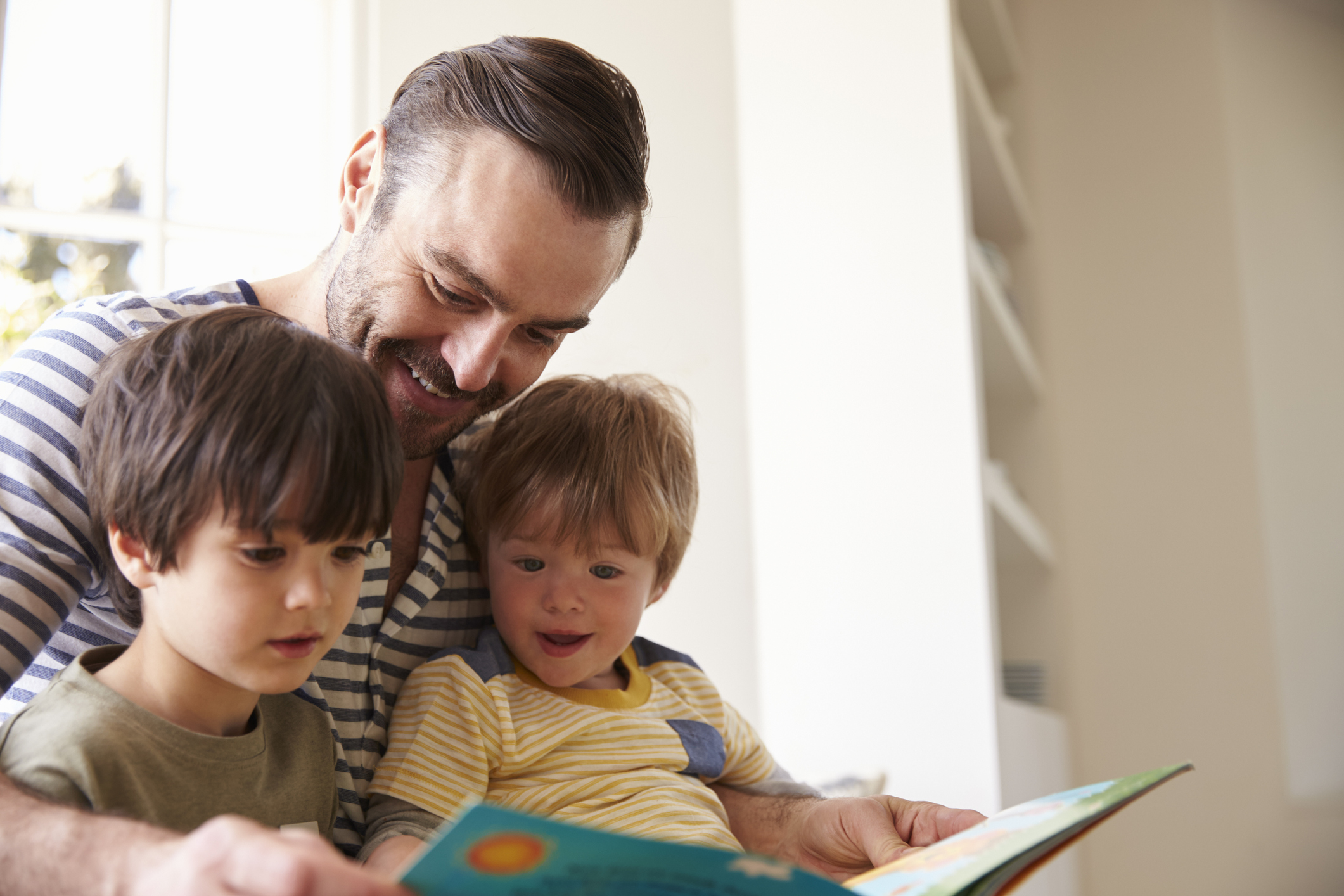 8 hilfreiche Kinderbücher zum Thema Umzug Vater liest seinen zwei Söhnen ein Buch vor