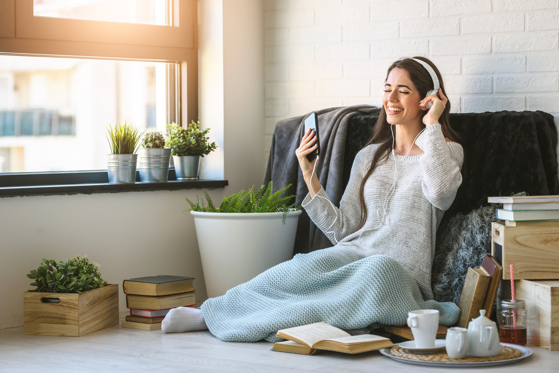 Junge Frau hört im Wohnzimmer Musik