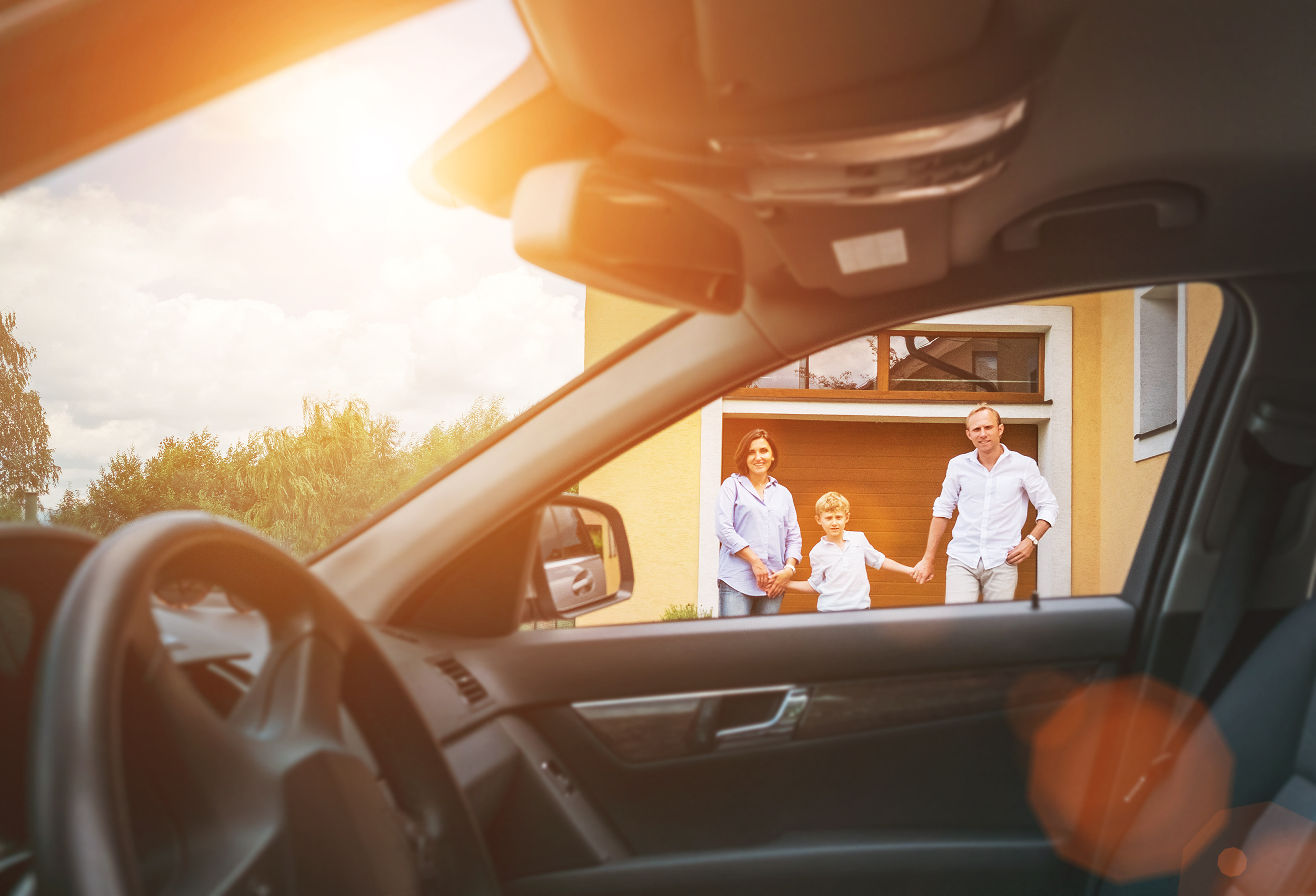 Mietvertrag für einen Stellplatz: Darauf müssen Sie achten Ein Auto und eine Familie vor ihrem Haus