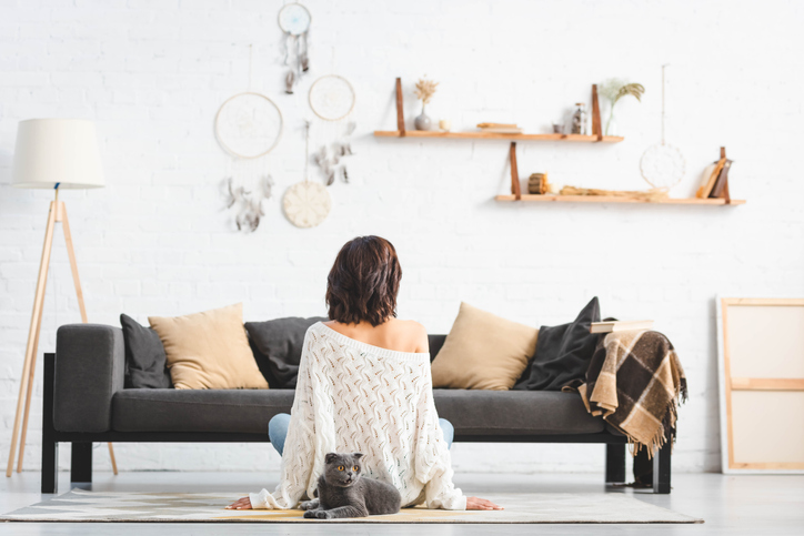 Minimalistisch wohnen Frau sitzt in minimalistischem Wohnzimmer
