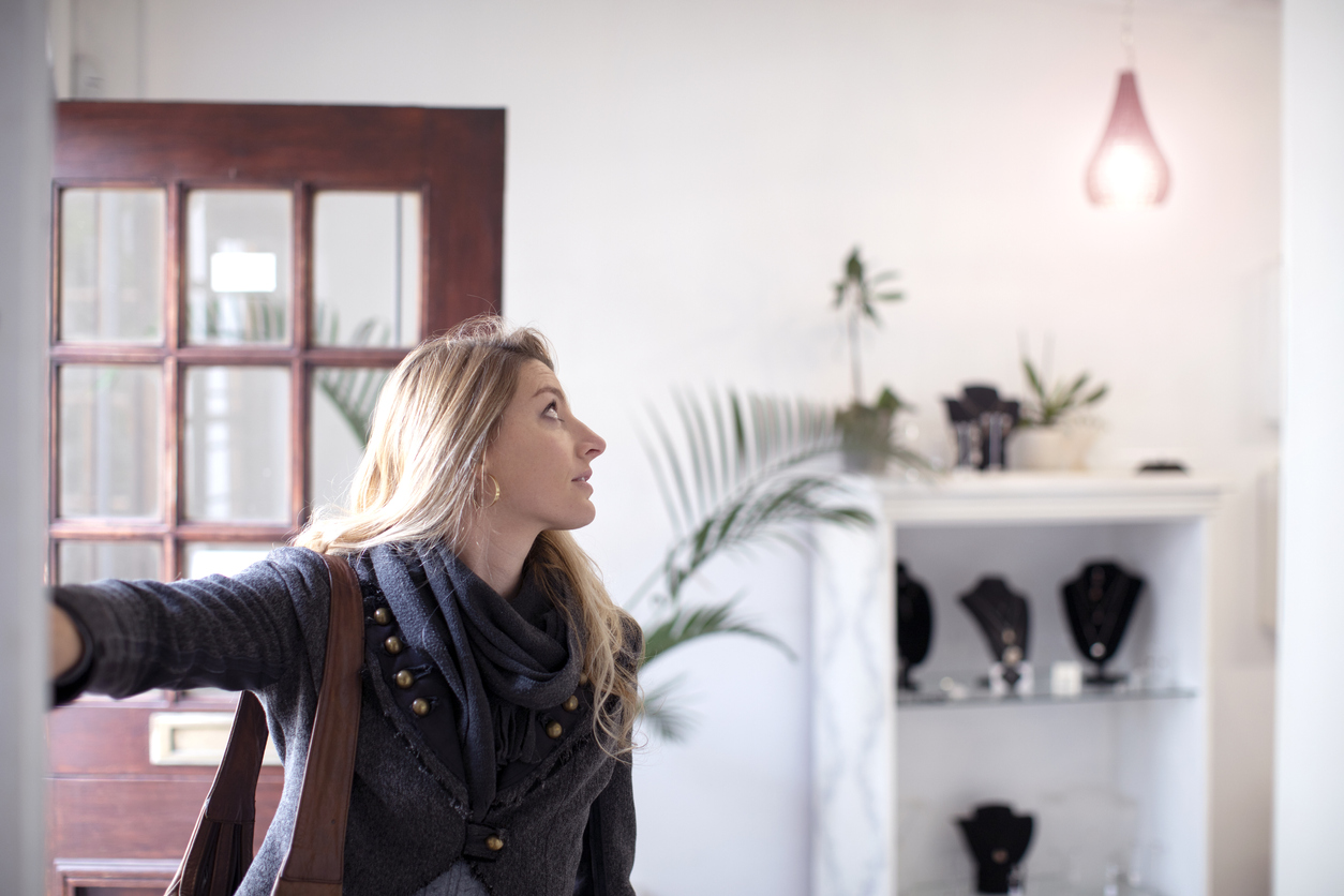 Frau schaltet Licht in neuer Wohnung ein