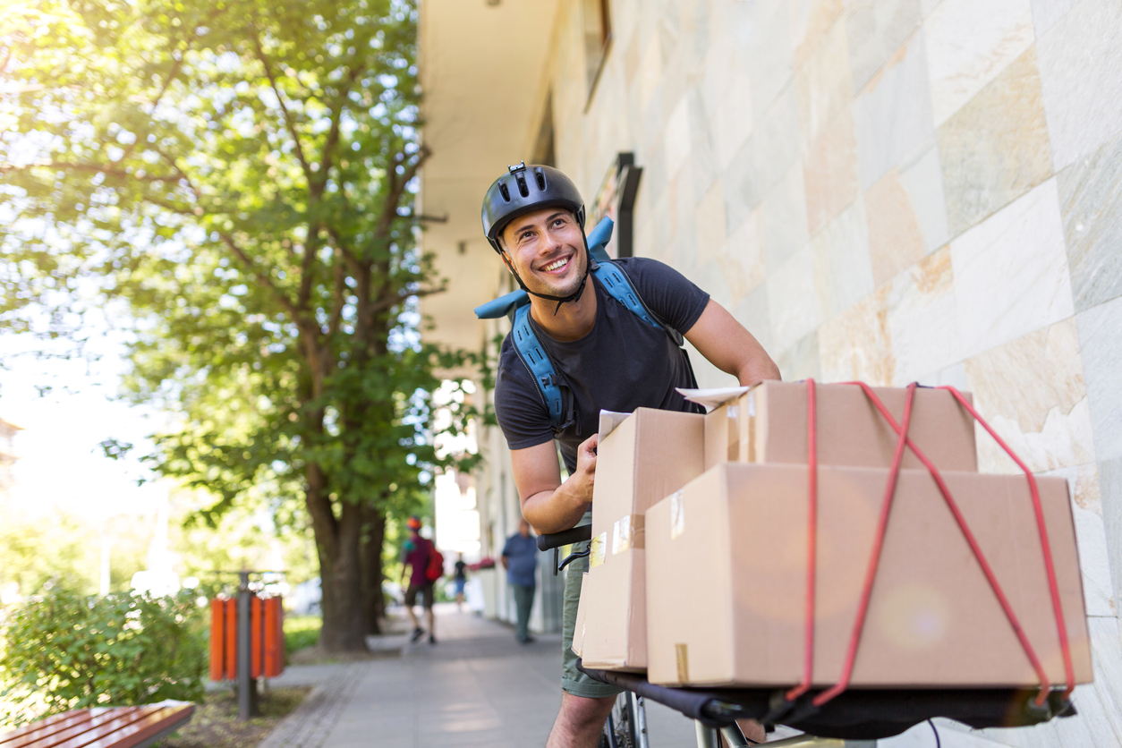 Umzug mit dem Fahrrad Mann auf Fahrrad, auf das Kartons geschnallt sind