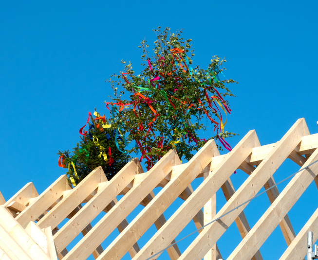 Richtfest feiern beim Hausbau: Diese Bräuche gehören zum Fest Richtbaum auf einem Dachstuhl
