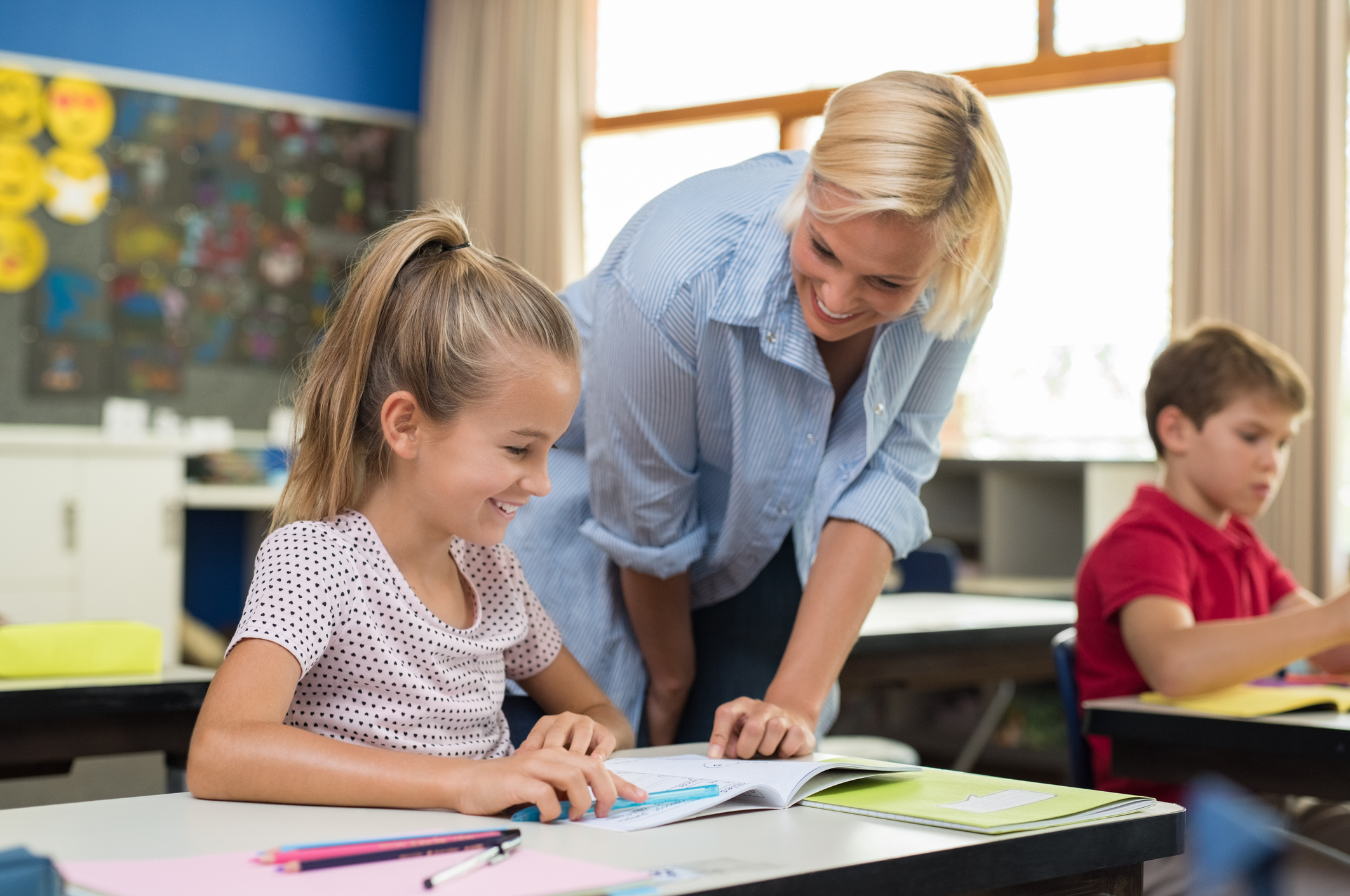 Schulwechsel wegen Umzug: Das müssen Eltern beachten Lehrerin erklärt Schülerin Aufgabe aus dem Lehrplan im Bundesland