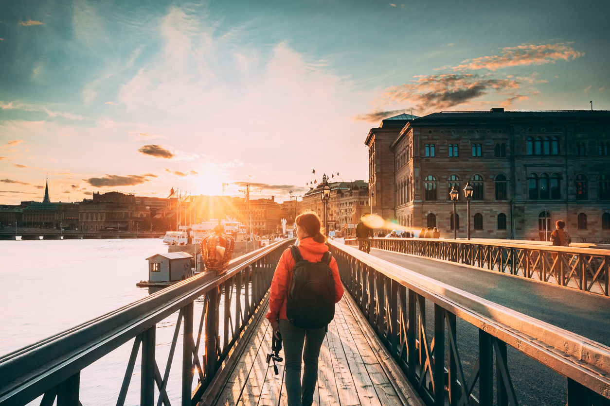 Auswandern nach Schweden: Das sollten Sie wissen Frau auf Brücke in Stockholm