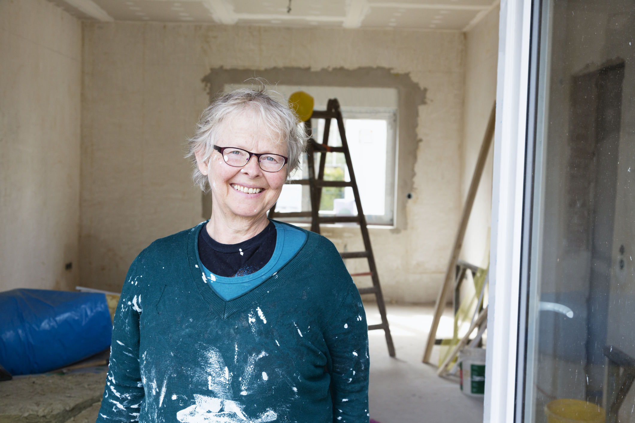 Seniorenumzug: Tipps für den Umzug im Alter Ältere Frau renoviert fröhlich eine Wohnung