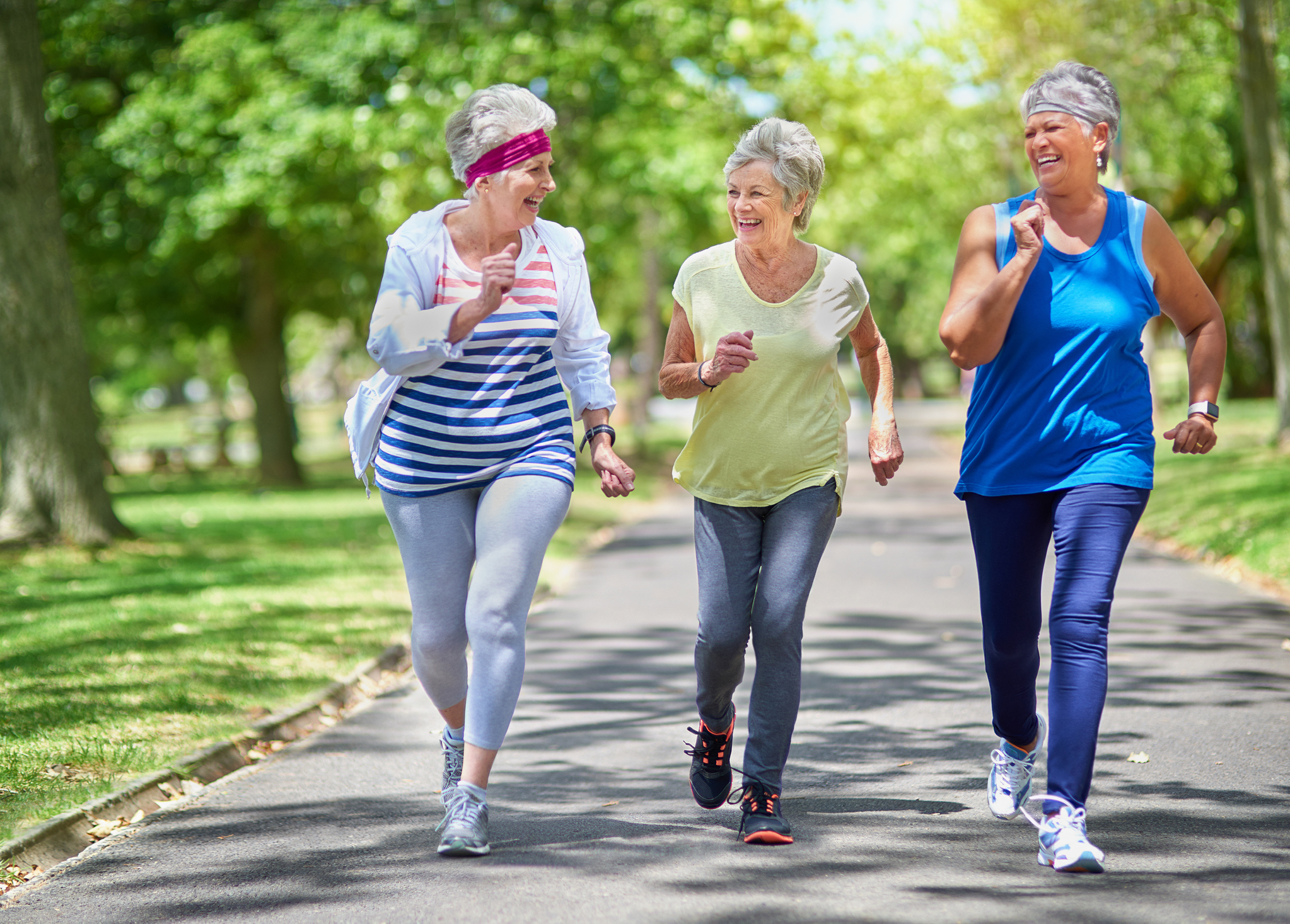 Senioren-WG: Modernes Lebenskonzept für Rentner und Best-Ager 50+ Drei ältere Frauen treiben im Park gemeinsam Sport