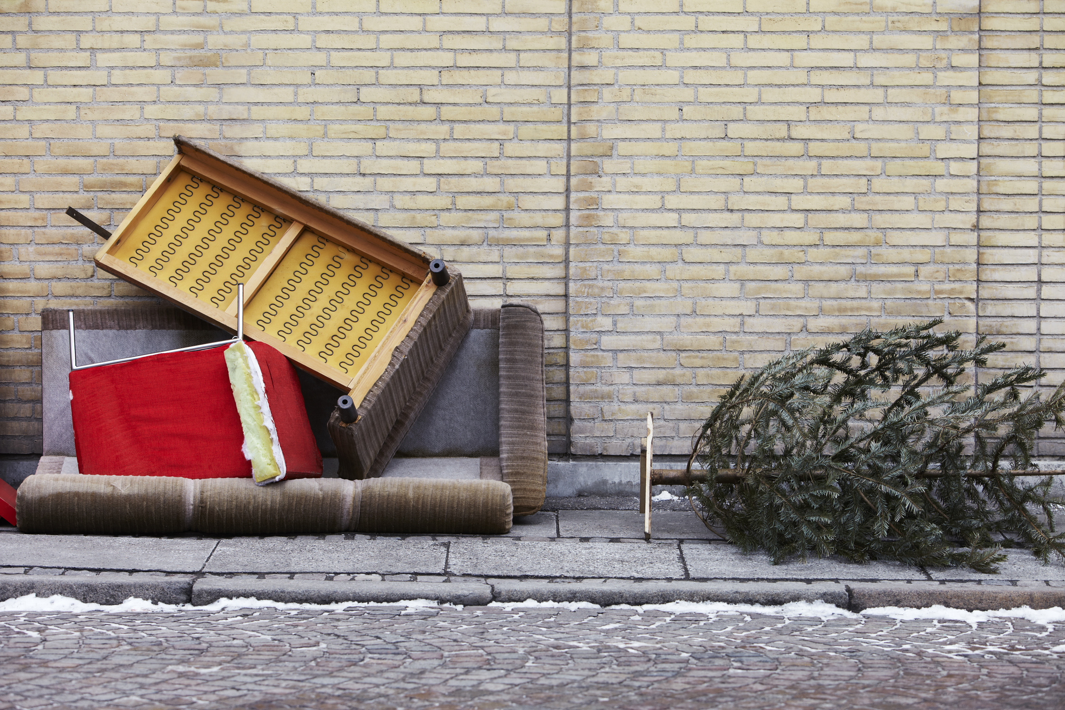 Altes Sofa und Weihnachtsbaum liegen als Sperrmüll auf der Straße