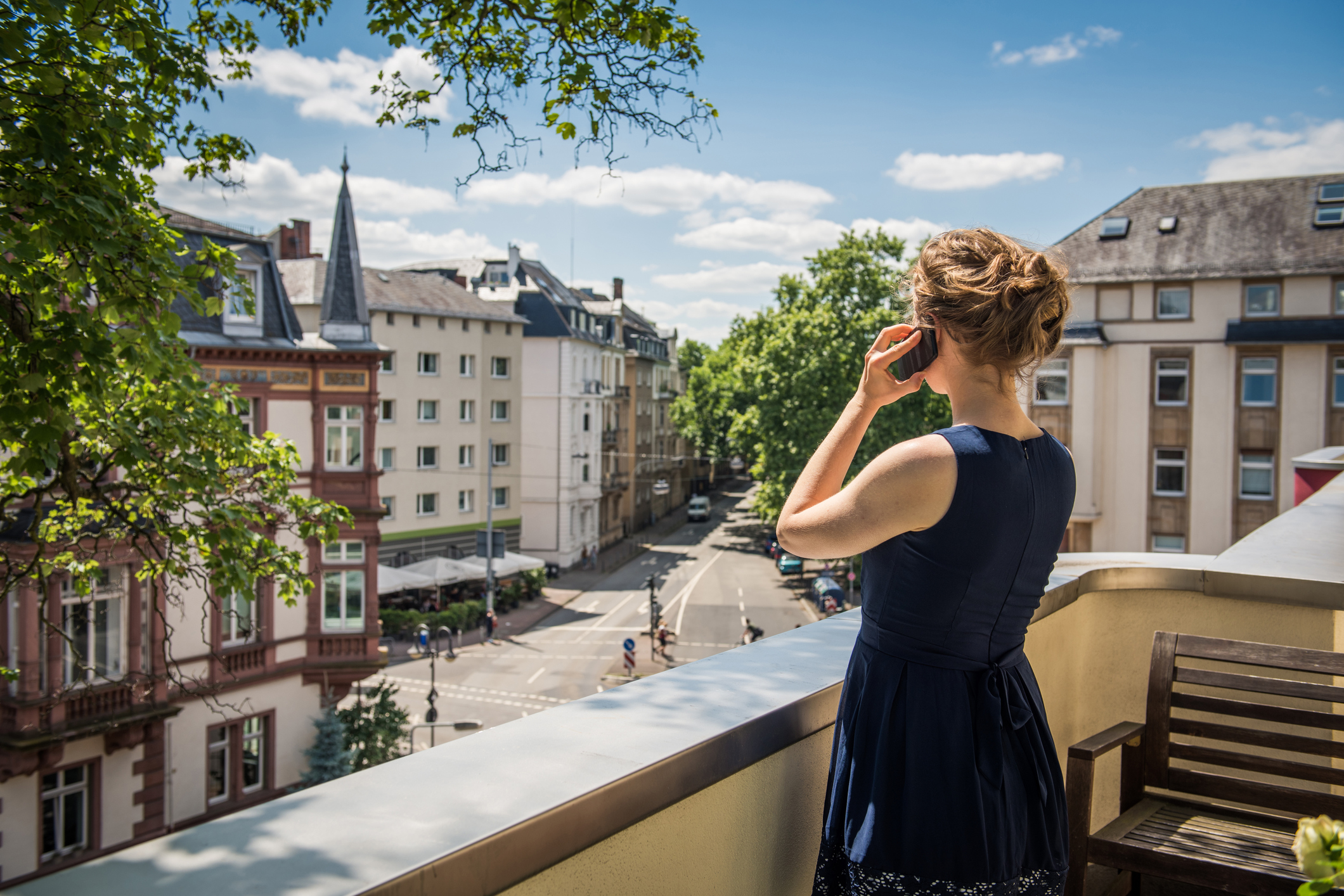 Junge Frau telefoniert auf dem Balkon