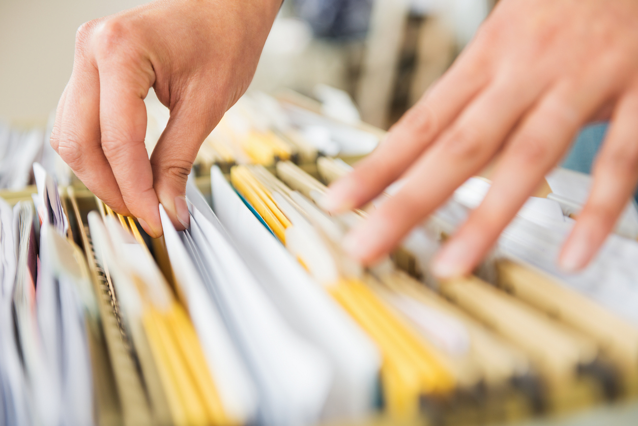 Grundbuch einsehen: Die wichtigsten Infos Hände durchsuchen Akten