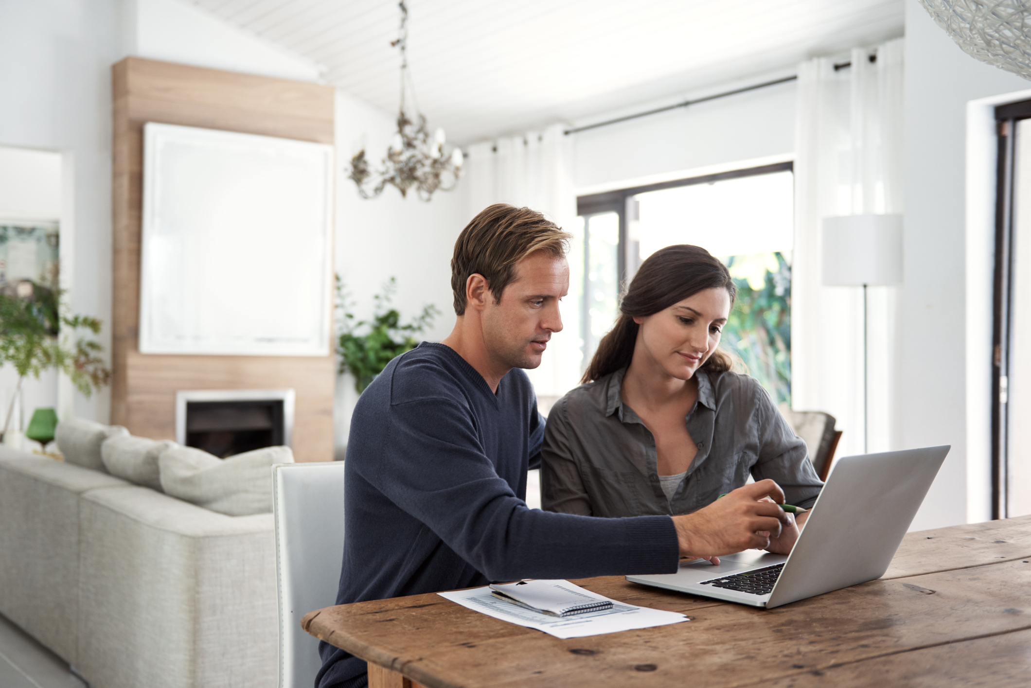Ummelden vor Umzug Paar sitzt vor PC mit Papieren und will sich vor Umzug ummelden