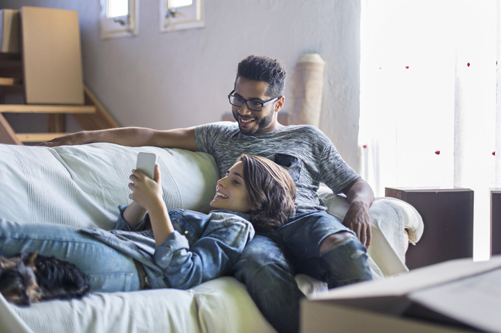 Umzugs-Checkliste: Alles, woran Sie denken müssen Paar ruht sich von Umzug auf dem Sofa aus.