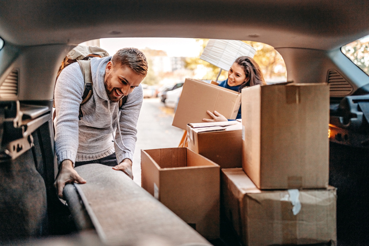 Umzug per Beiladung: Wann lohnt sich der Sammeltransport? Junge Paar belädt Auto
