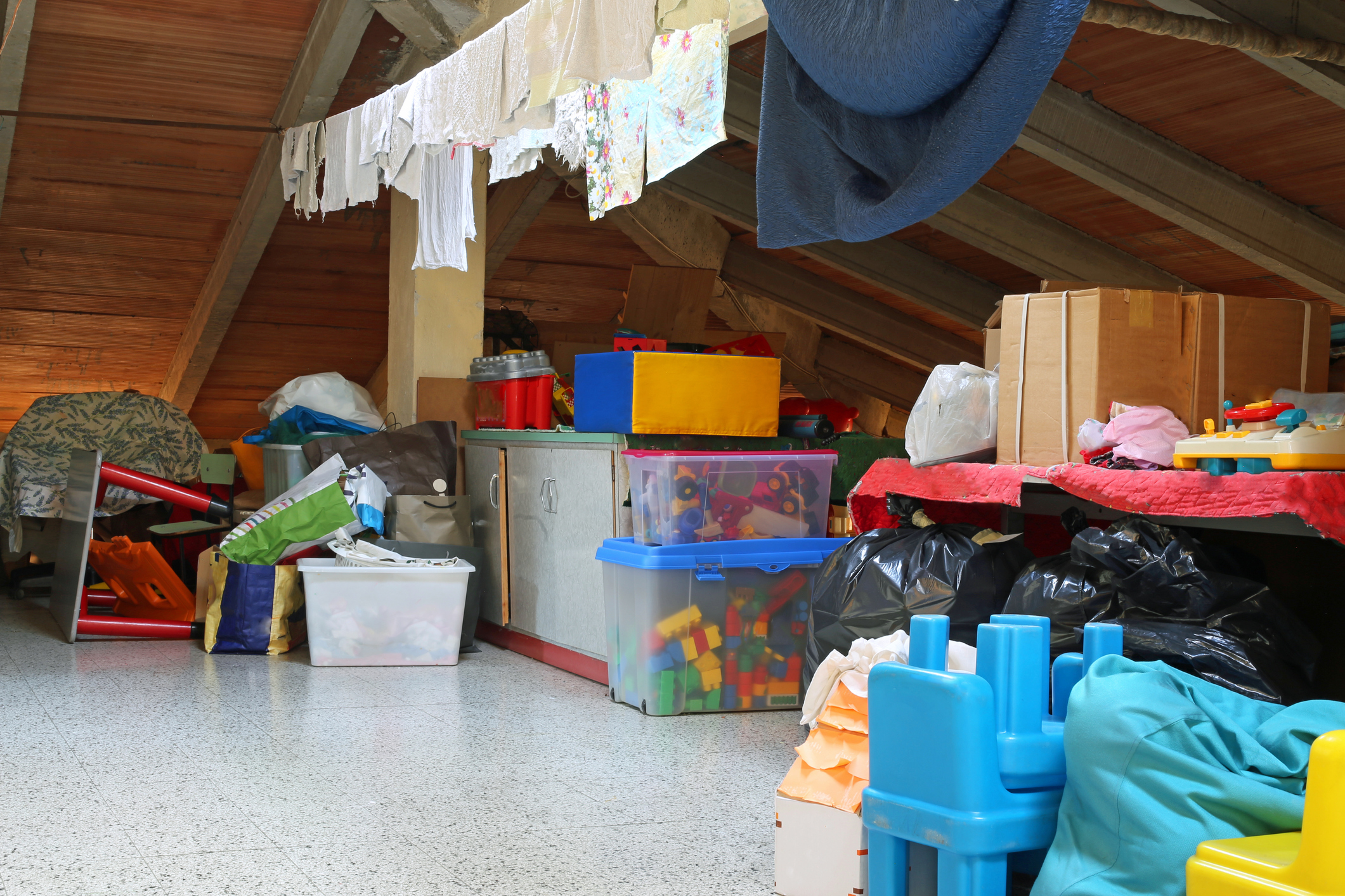 Umzug planen: Tipps für den DIY-Umzug Dachboden voller Kisten mit Spielzeug und Wäscheleine