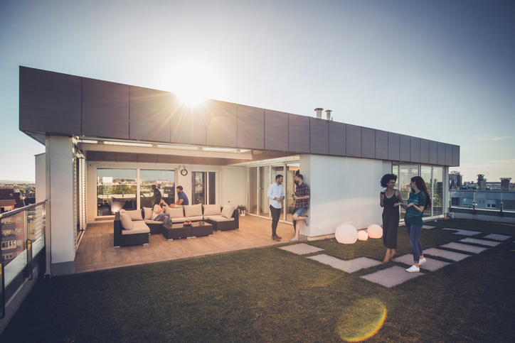 Was ist eine Penthouse-Wohnung und welche Vor- und Nachteile hat sie? Menschen auf Terrasse von Penthouse