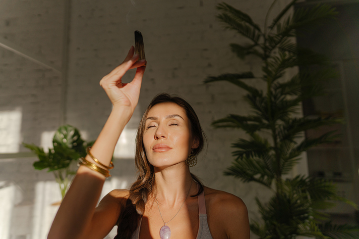 Wohnung ausräuchern: Was steckt dahinter? Frau in Wohnung mit weißem Salbei