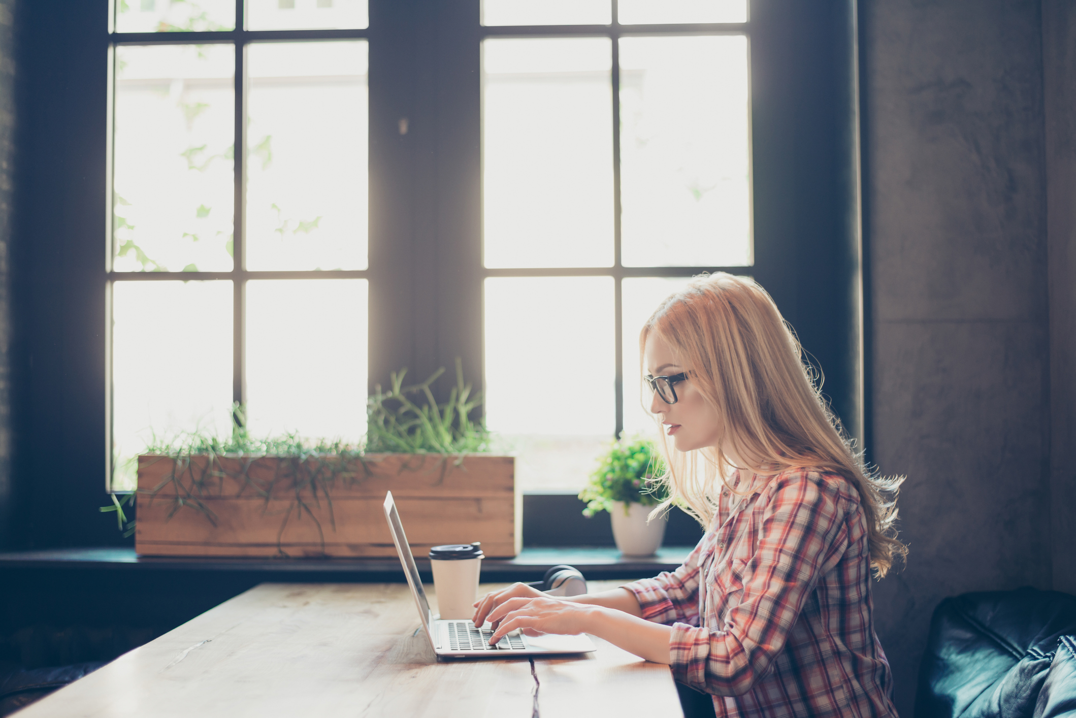 Wohnungssuche per Anzeige: Tipps für Suchende Frau arbeitet an einem Tisch an einem Laptop