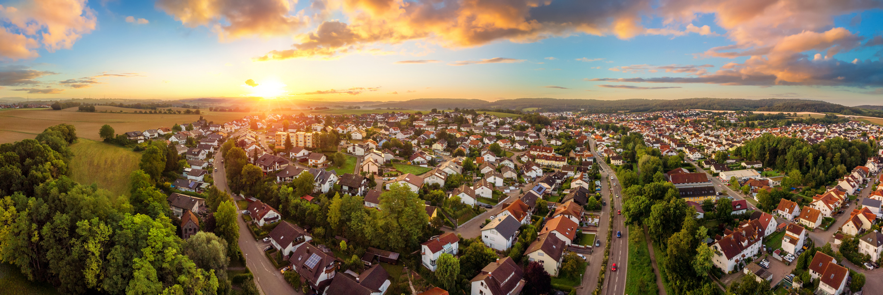 Wohnungssuche: Unterschiede zwischen Stadt und Land Luftbild der Kleinstadt bei Sonnenaufgang