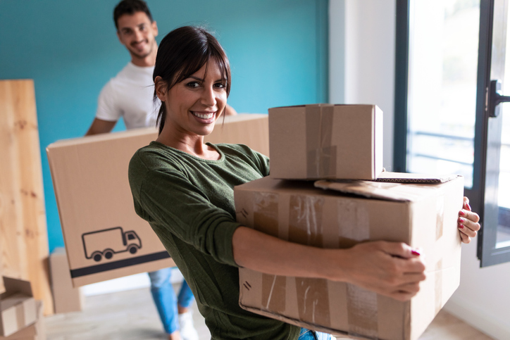 Zum Umzug: 20 originelle Sprüche und Zitate, die Sie so noch nicht kennen Junges Paar trägt Umzugskartons in die neue Wohnung