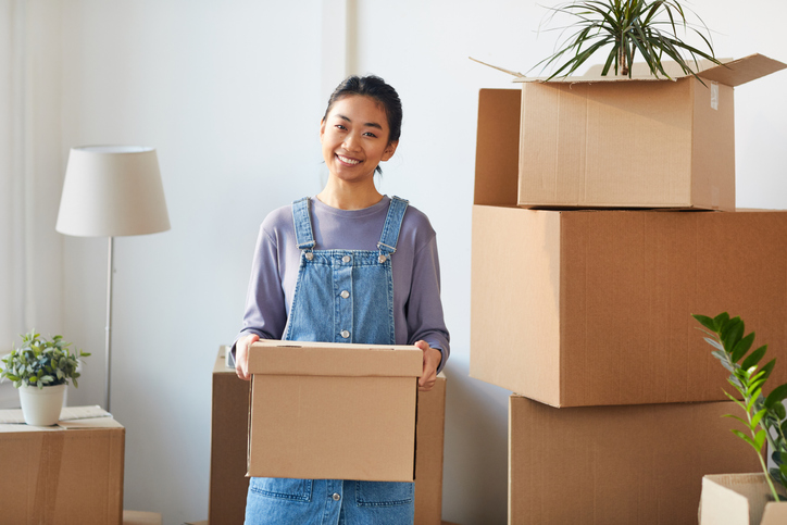 Junge Frau mit Umzugskartons bereitet sich auf den Auszug vor