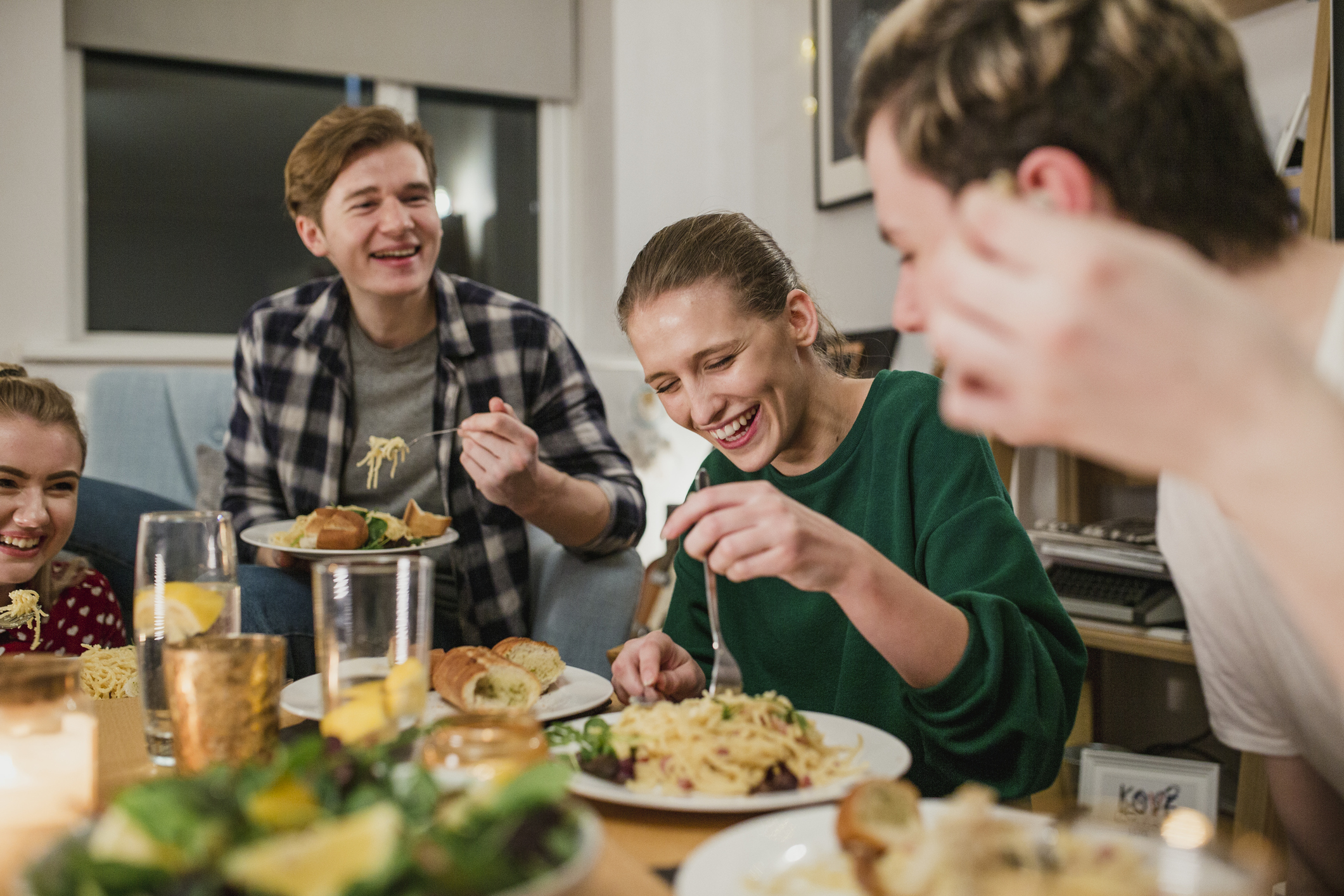 Wohnen als Student: Allein, WG, Wohnheim – was ist am besten? Lachende junge Leute kochen und essen zusammen
