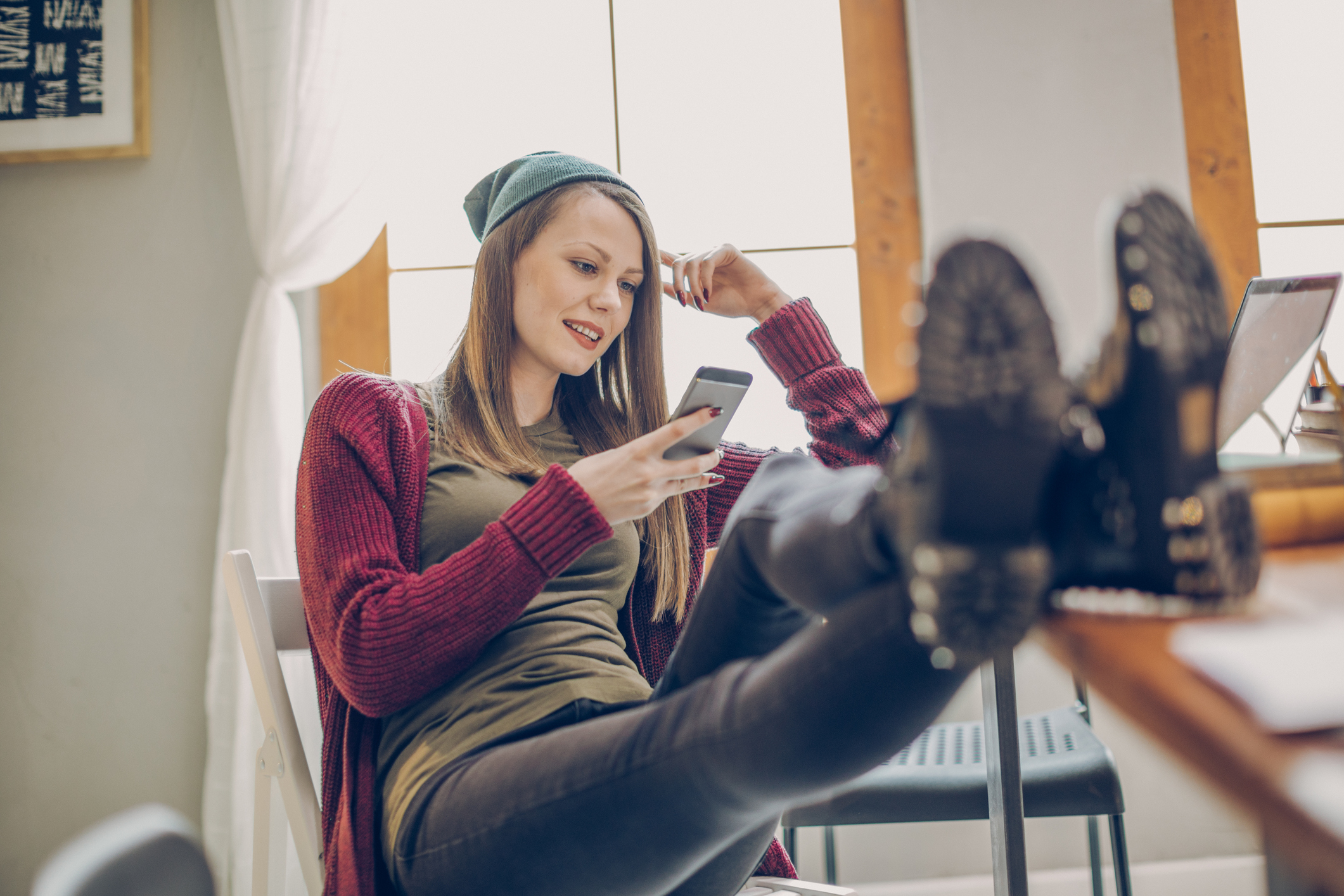 Wohnen als Student: Allein, WG, Wohnheim – was ist am besten? Zufriedene Studentin sitzt gemütlich am Schreibtisch