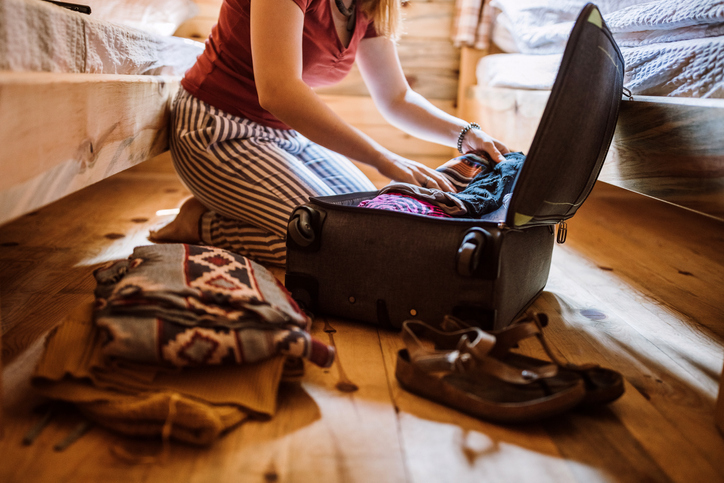 Preisgünstige Alternativen zu Umzugskartons Frau packt Koffer