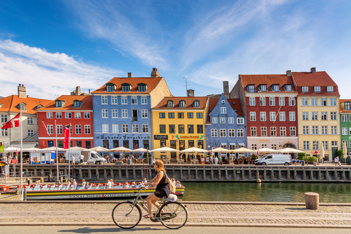Hej, Hygge-Feeling: Auswandern nach Dänemark Frau radelt durch Kopenhagen