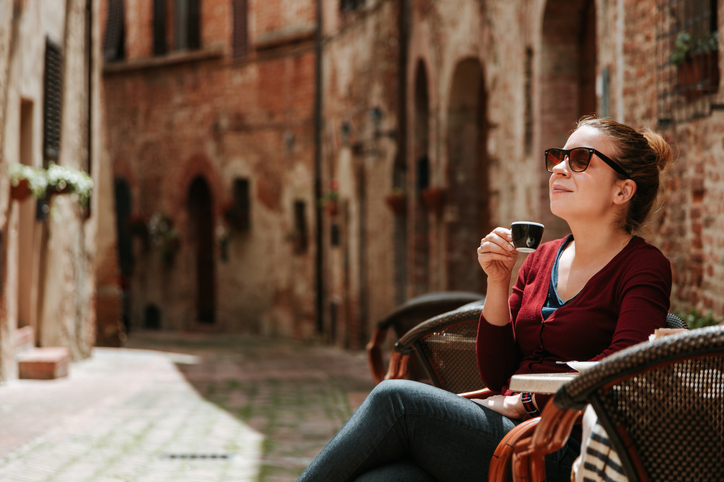 Auswandern nach Italien Kaffee Junge Frau trinkt eine Tasse Espresso im Café in einer italienischen Altstadt