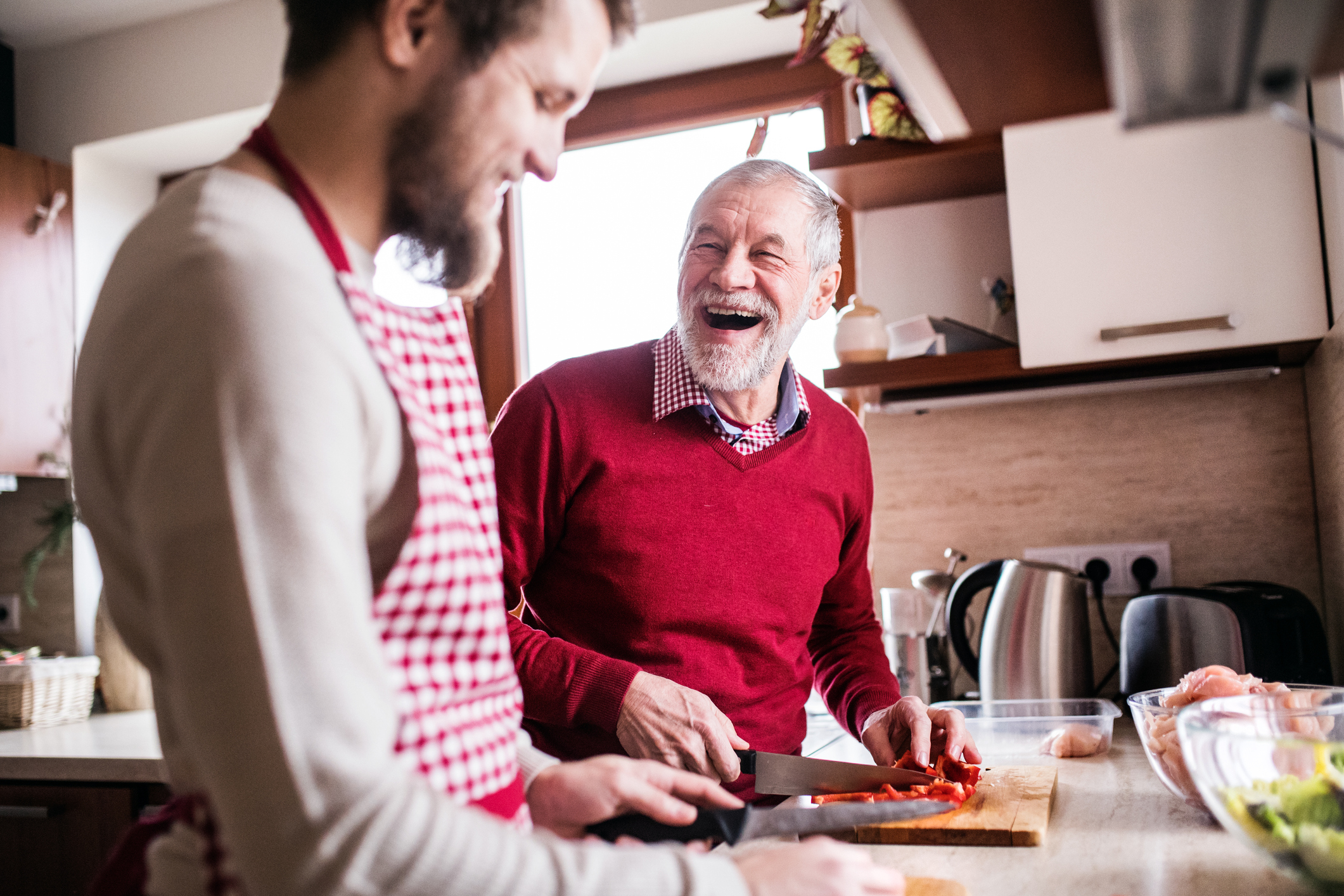 Junger und älterer Mann kochen gemeinsam