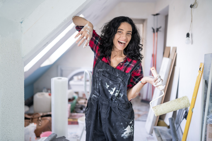 Dachboden ausbauen: Alles rund um die Renovierung Frau baut Dachboden aus