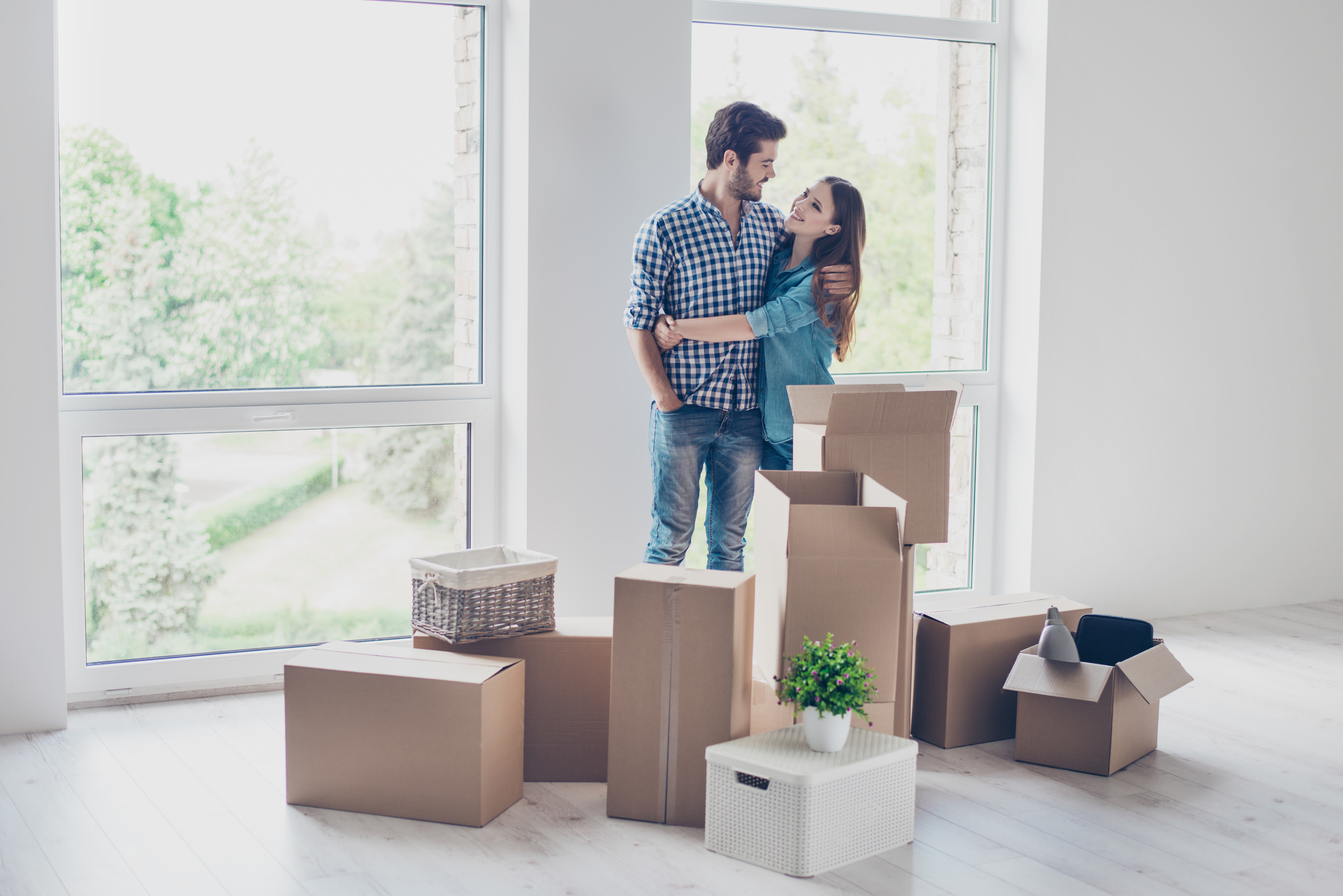 Abstandszahlung für die Wohnung: Was ist das und was ist erlaubt? Paar steht zwischen Umzugkartons und umarmt sich