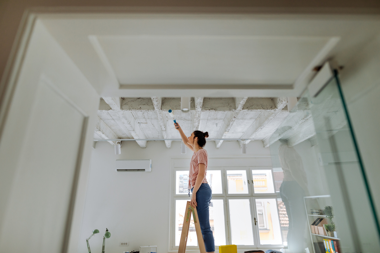 Decke streichen: Über Kopf ohne Spritzer und Streifen Junge Frau streicht über Kopf die Decke