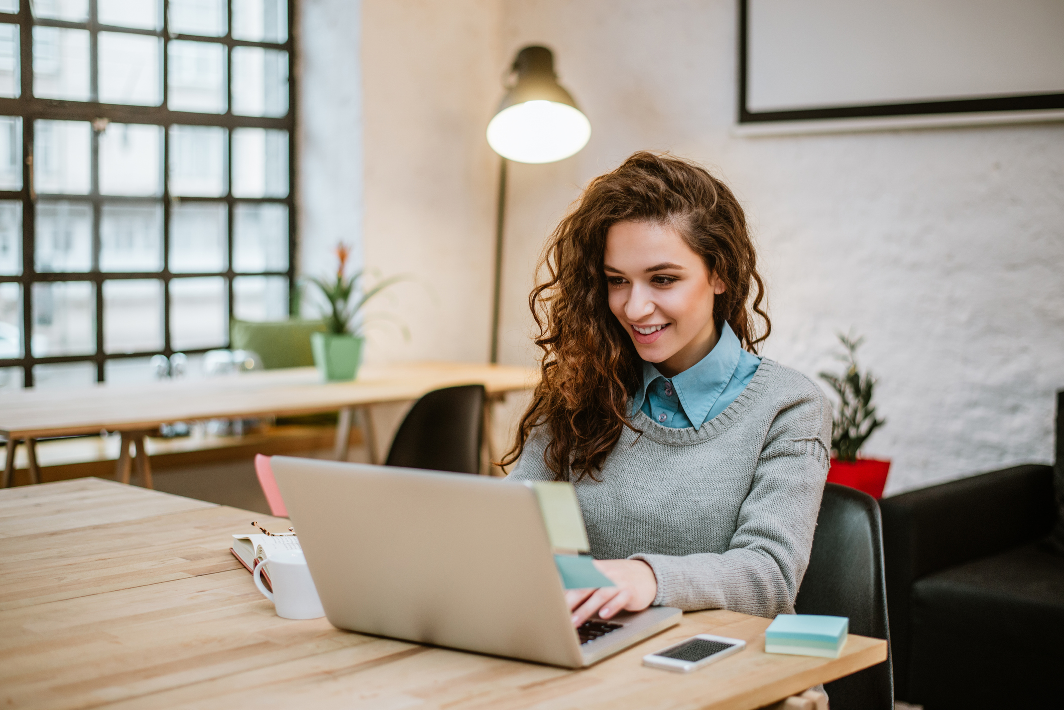 Successful young woman in modern office working on laptop. Junge Frau am Laptop