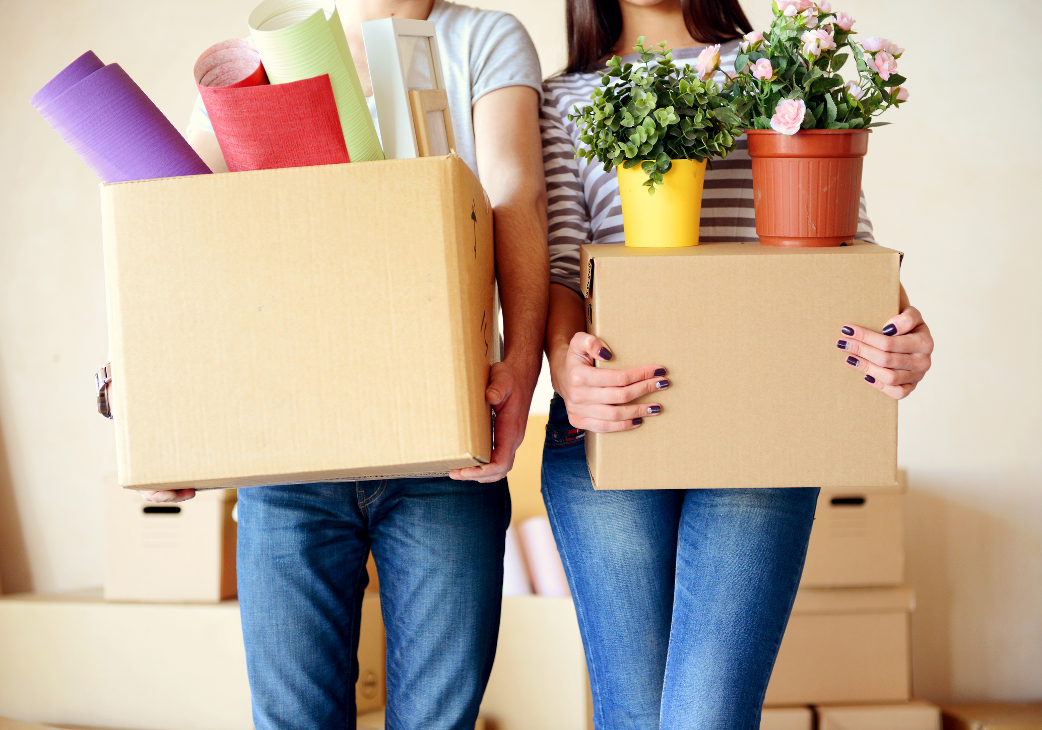 Fristlose Kündigung der Wohnung: Ist das erlaubt? Paar steht mit gepackten Umzugskartons im Wohnzimmer