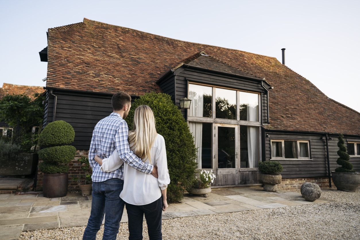 Haus geerbt: Was nun, alles, was Sie über Verkaufen und Co. wissen müssen Junges Paar steht vor Haus