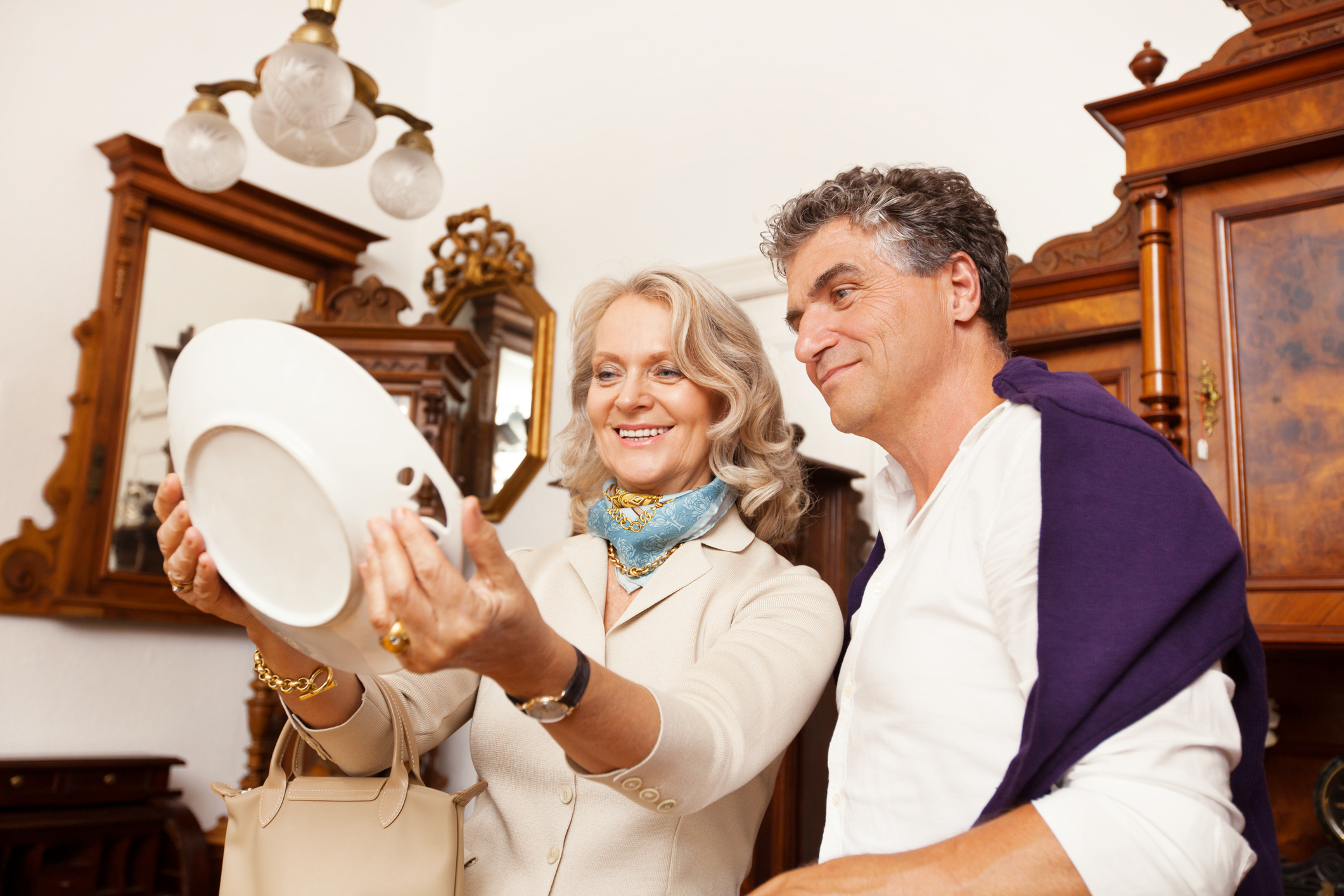 Älteres Ehepaar mit antiken Möbeln und teurem Porzellan