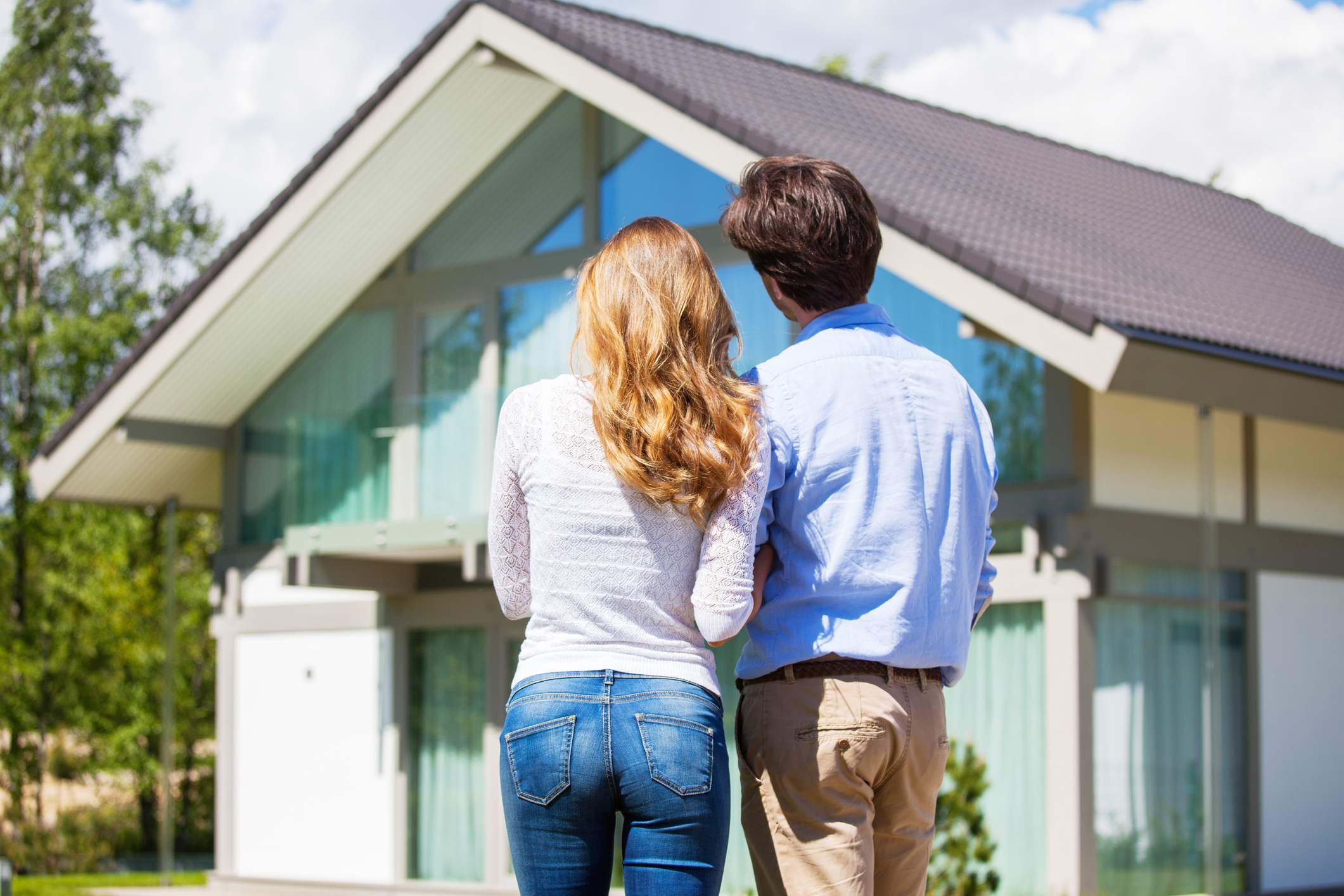 Haus kaufen oder mieten: Was ist das Richtige für mich? Paar vor einem Haus